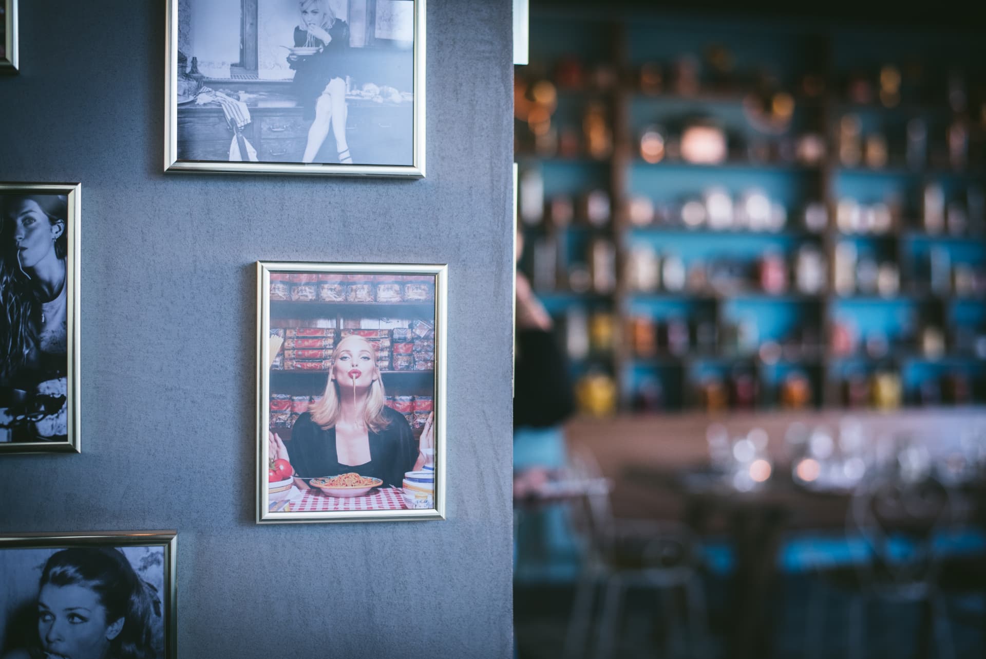 The concrete walls of Un Po' Di Più hung with framed photographs, a warm interior atmosphere