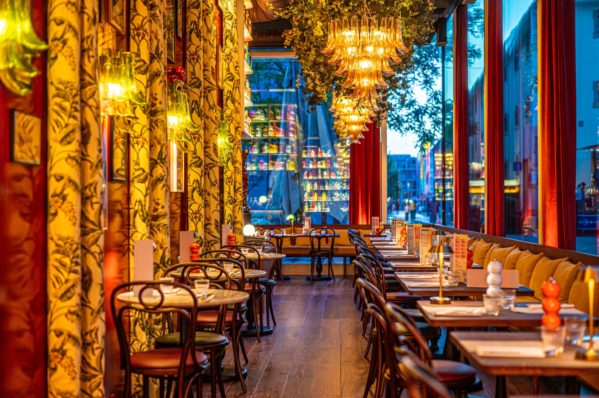 A row of laid tables at Gran Torino along the large windows looking onto the Flon